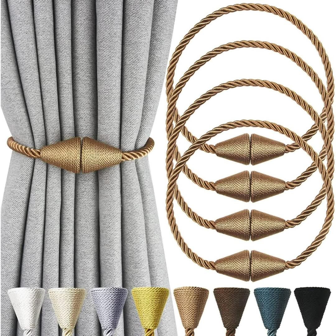 A pair of gold woven magnetic curtain tiebacks holding grey drapes together.