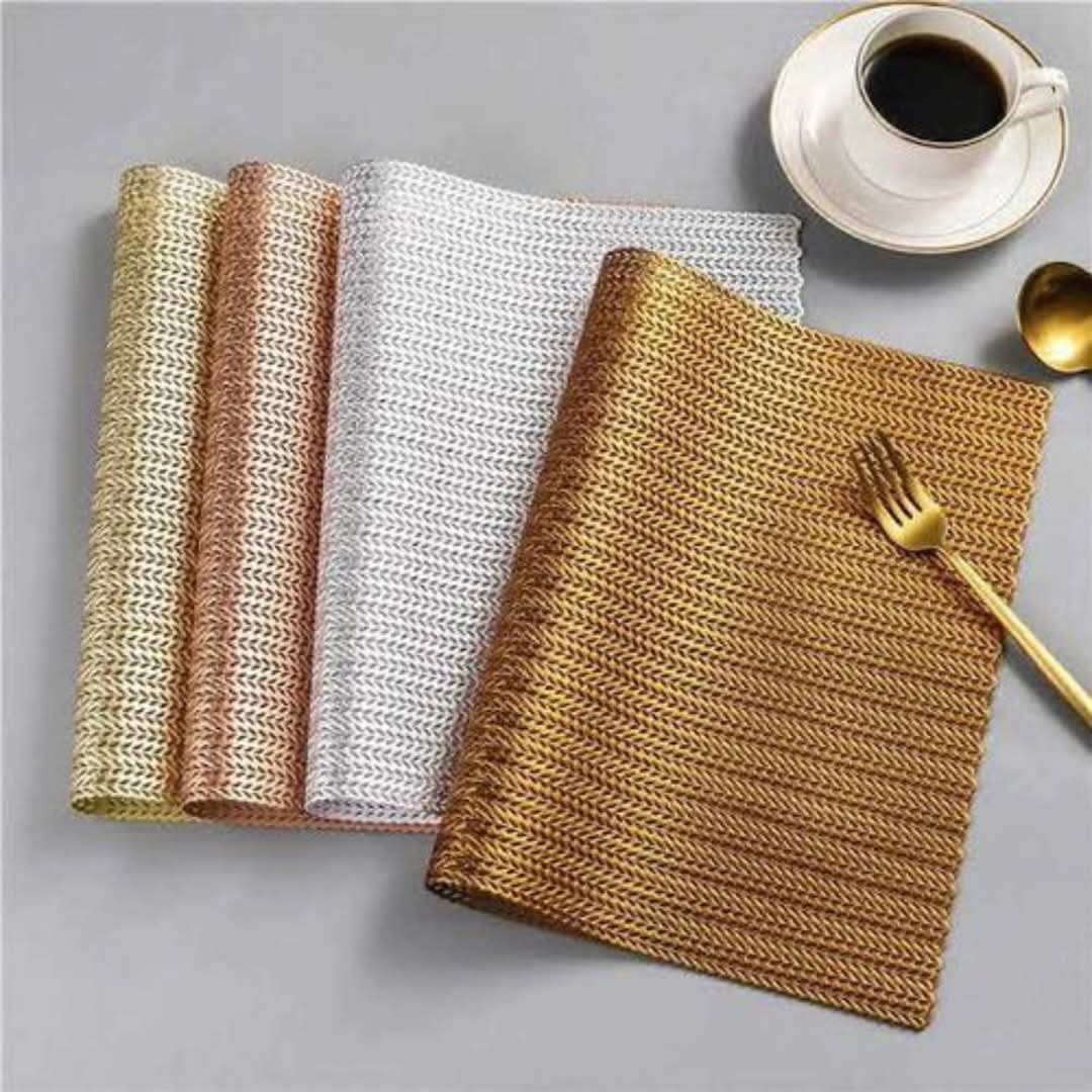 A set of six woven metallic placemats in gold, silver, and rose gold.