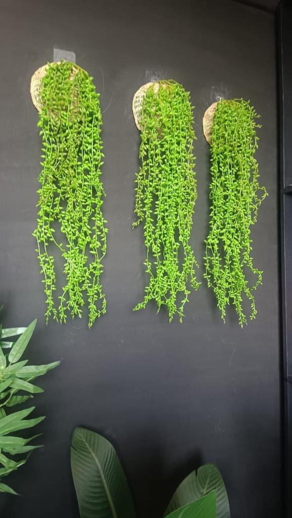 A set featuring one artificial flowing green plant and one woven basket