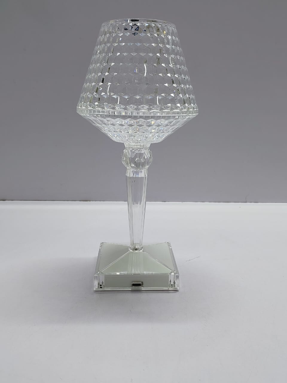 A rechargeable diamond shaped crystal table lamp with a remote control and color changing features.