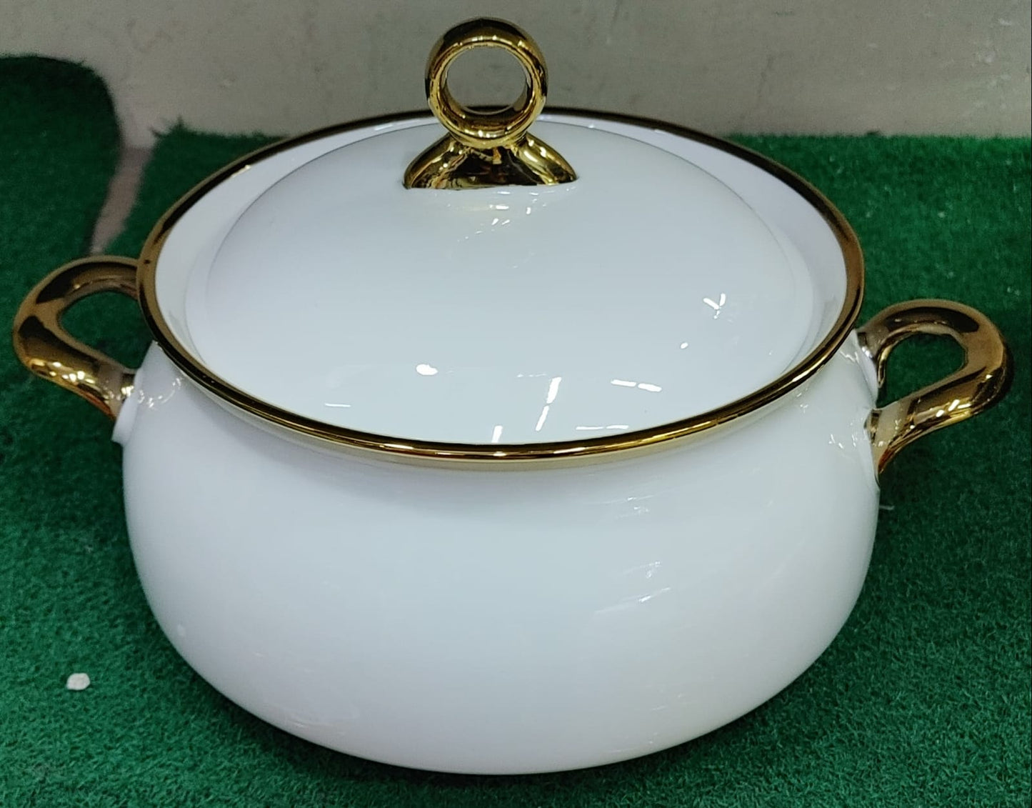Three white ceramic serving bowls with gold rims and handles