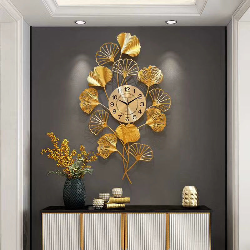 Large gold wrought iron wall clock featuring a decorative gingko leaf design