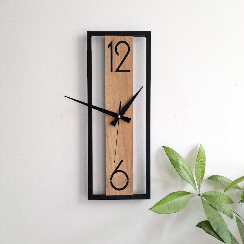 A modern minimalist rectangular wooden wall clock with black numerals and hands, framed in black.