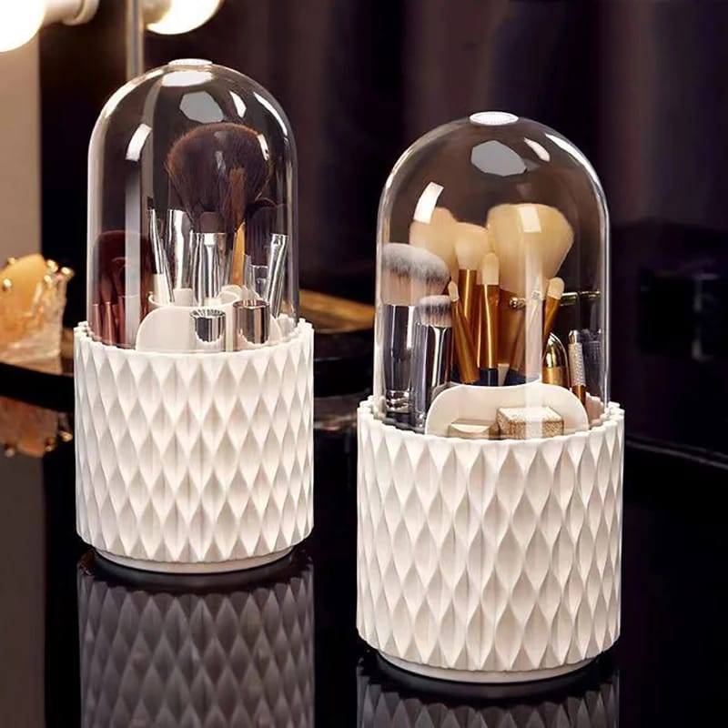 Two cylindrical white cosmetic brush holders with a diamond pattern texture and clear dome lids, filled with makeup brushes.