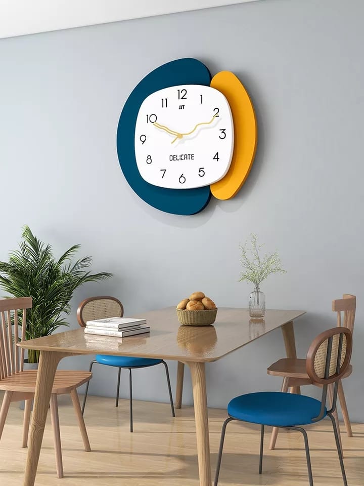 A wall clock with a white, blue, and yellow design