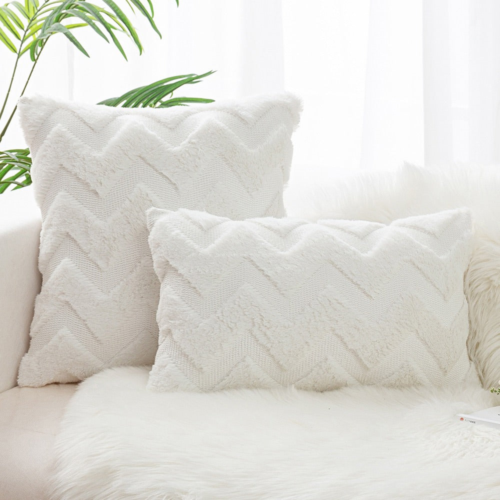 Two white plush cushion covers with a raised zigzag wave pattern