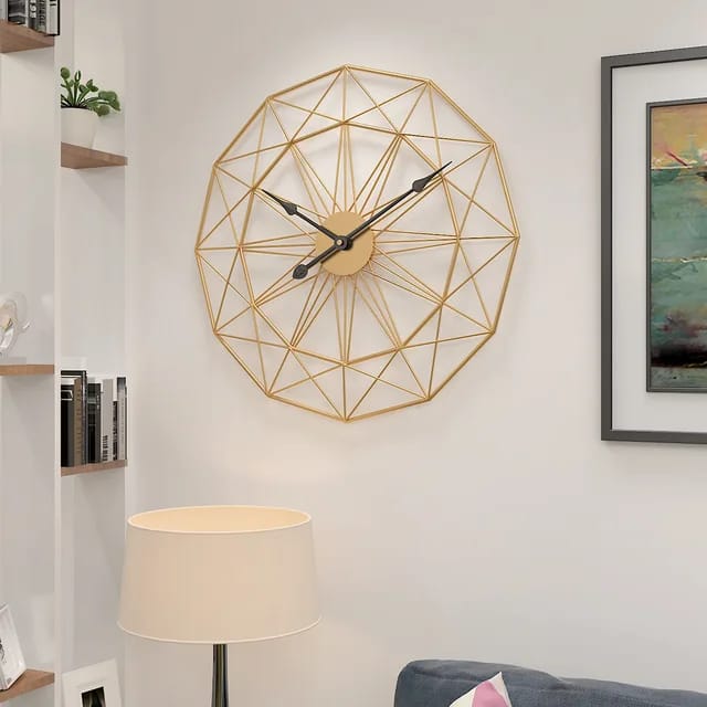 A golden wall clock with a geometric pattern
