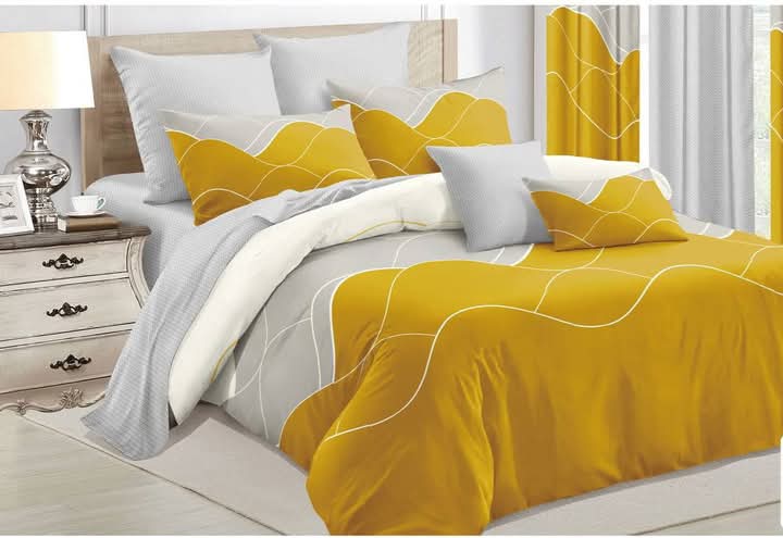 A fully made king size bed with a duvet cover set featuring a modern abstract wave pattern in bold mustard yellow and light grey colors.