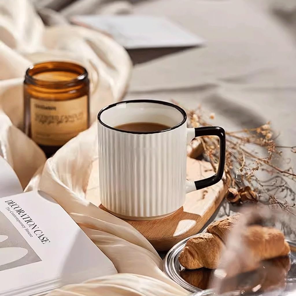 A ribbed, cream colored ceramic coffee mug with a black handle and rim.