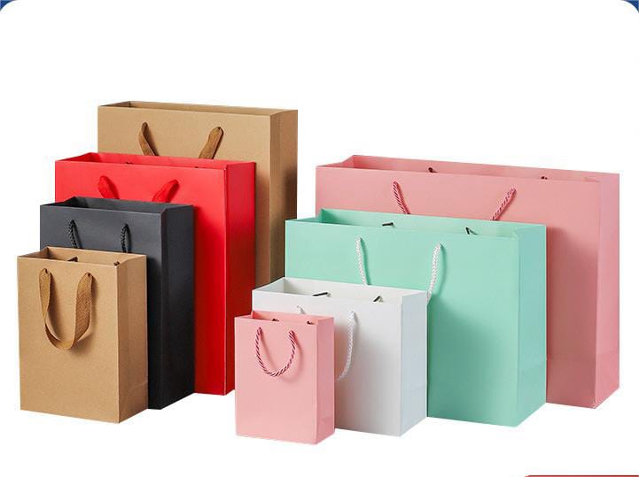 A variety of colorful paper gift bags in different sizes, including shades of pink, mint green, white, red, and brown.