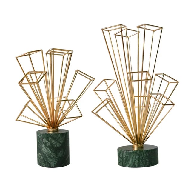 Gold geometric metal starburst sculptures with green marble cylindrical bases.
