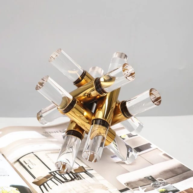 An abstract gold metal and clear acrylic geometric sculpture