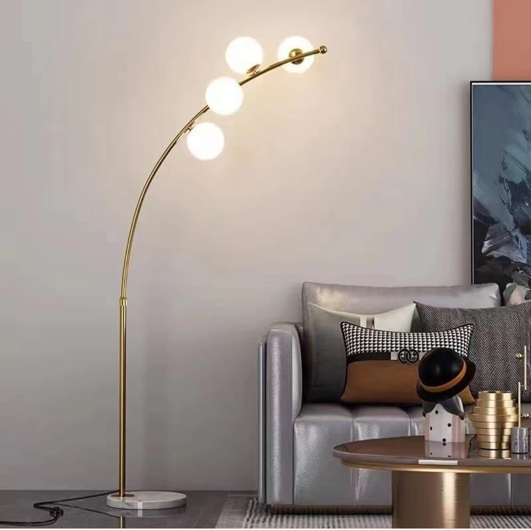 A gold arc floor lamp with four white glass bubble shades