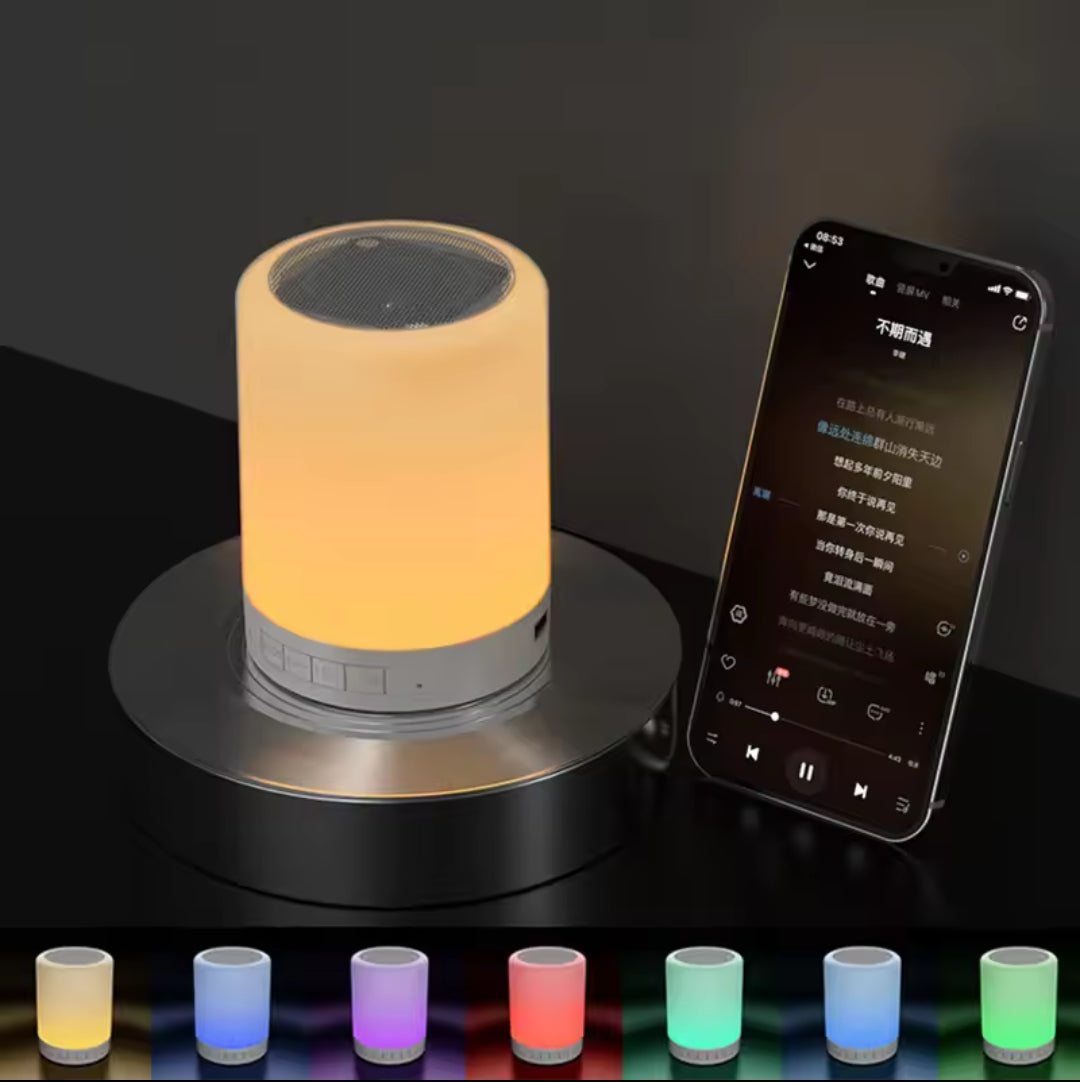 A small cylindrical white bedside lamp glowing with warm orange light