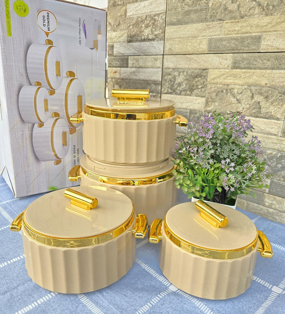 Set of four beige insulated hotpots with gold trim and matching lids