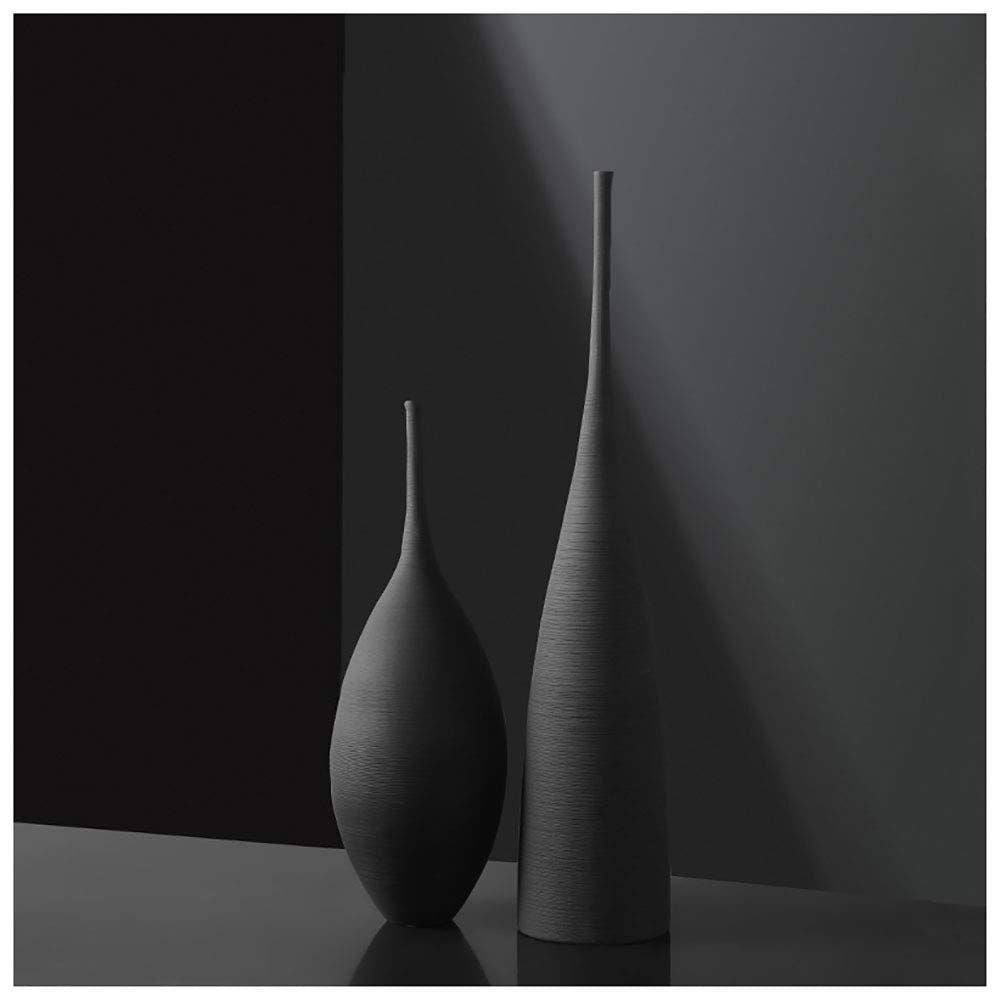 A set of two tall, slim black ceramic vases, one conical and one teardrop-shaped, with a subtle textured finish, displayed against a dark gray background.