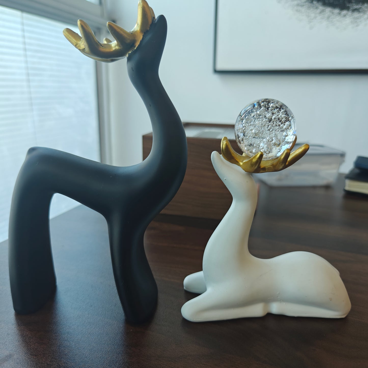 Two decorative sika deer figurines in black and white with gold horns