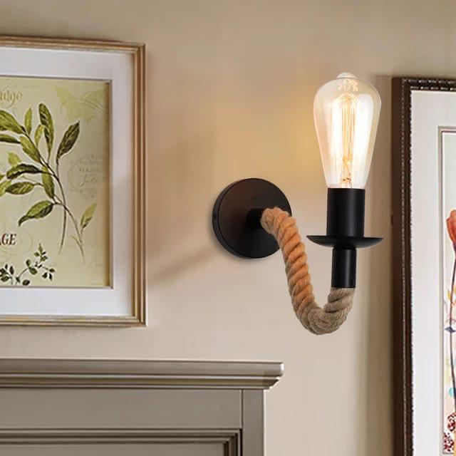 A wall lamp featuring a black base and an arm wrapped in hemp rope holding a clear bulb.