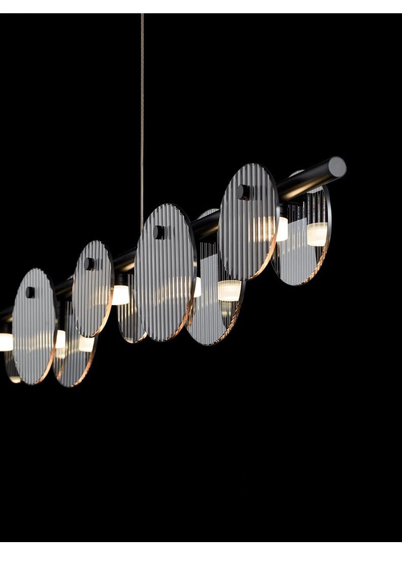 Linear black pendant light with smoky ribbed glass discs arranged along a horizontal metal rod.