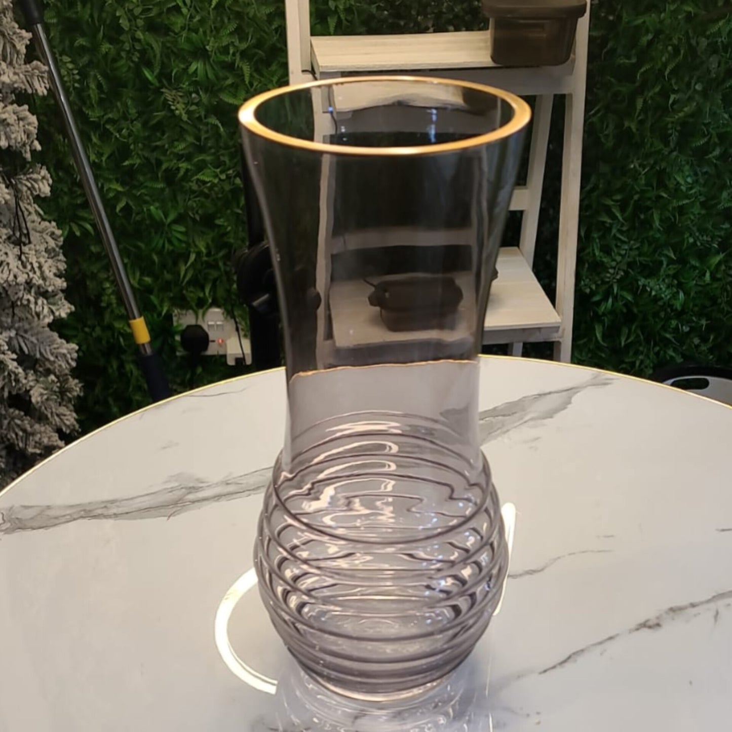 A 35cm tall dark-tinted glass vase with a ribbed base and gold rim