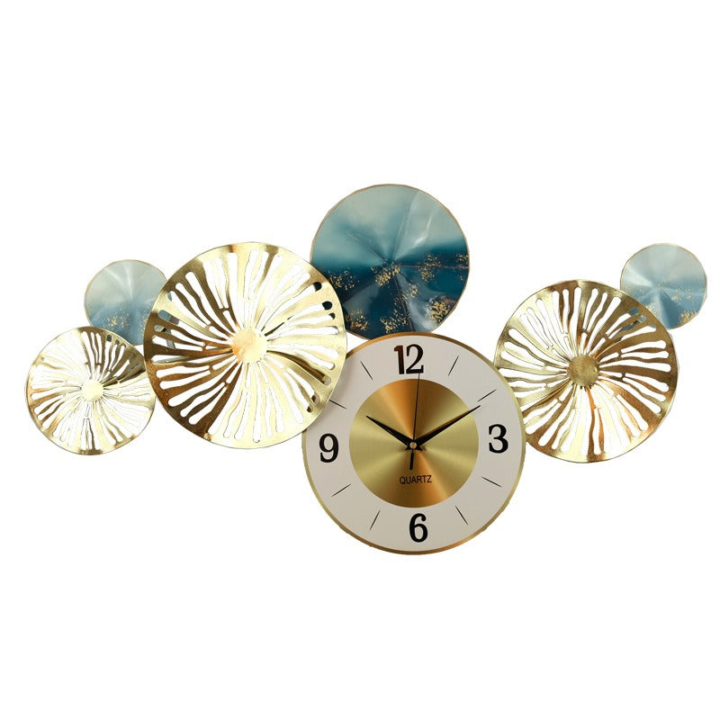 A horizontal wall clock featuring several overlapping metal discs in gold and teal patterns.