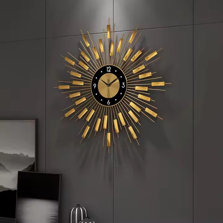 A large gold sunburst wall clock with a black dial and gold rays.