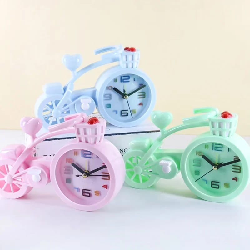 small bicycle shaped alarm clocks in pink, blue, and green.