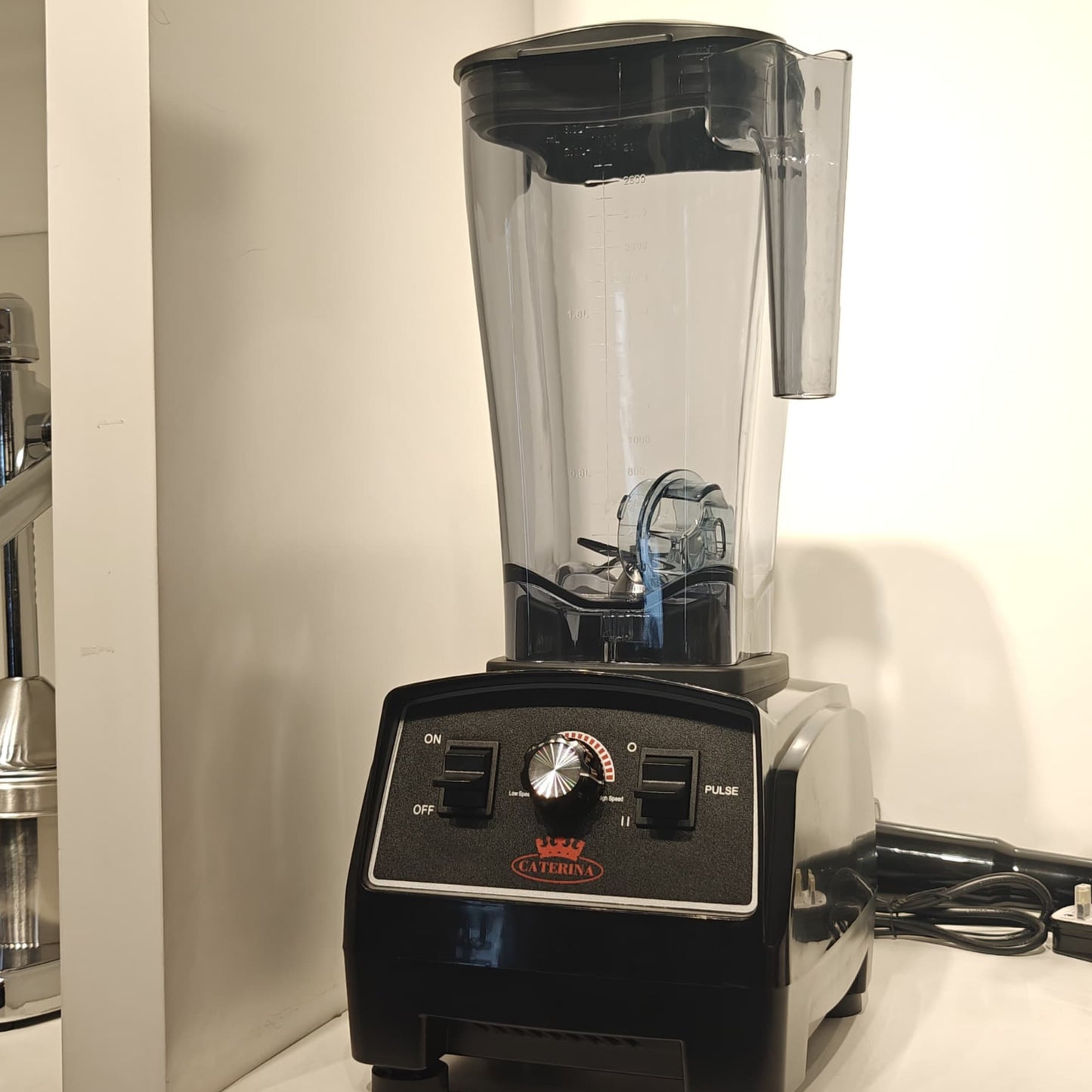 A black commercial-style blender with a clear pitcher, featuring speed control dials and the brand name 'CATERINA' on a white counter.