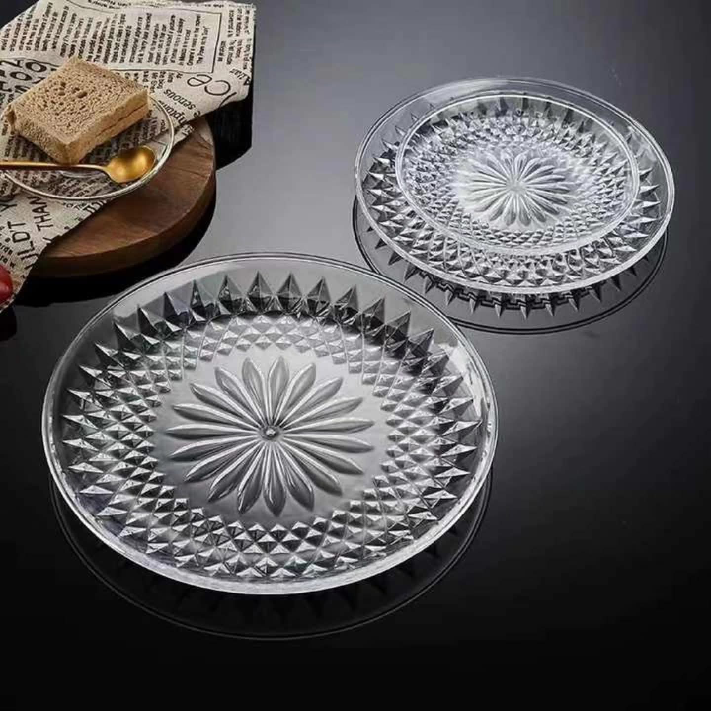 Clear round acrylic serving tray with textured sunburst pattern
