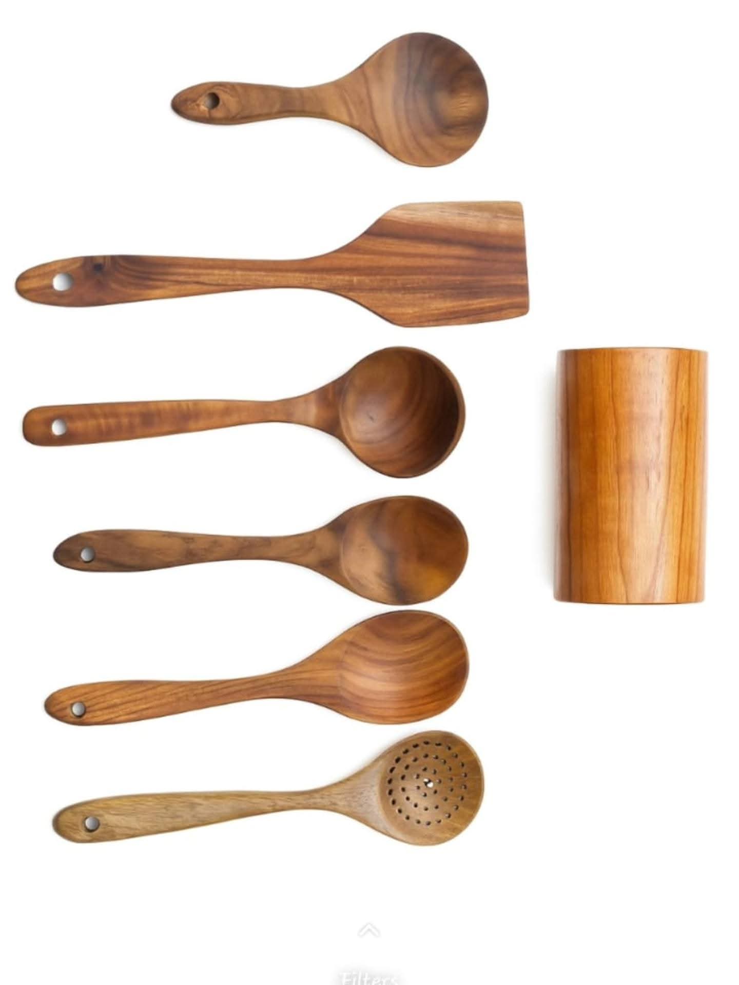 A set of six dark wooden cooking utensils including spoons and a spatula, laid out next to a matching cylindrical wooden storage holder.