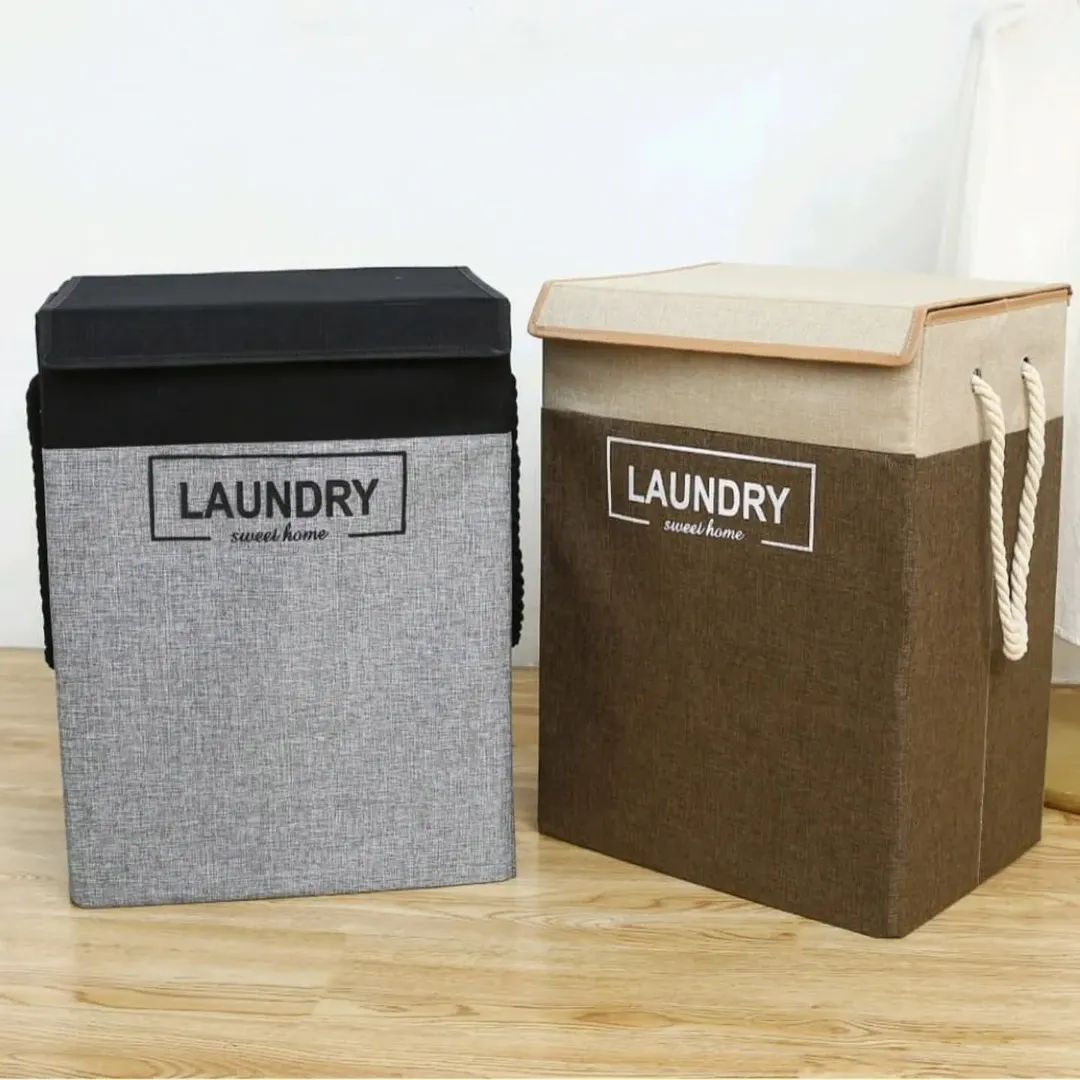Two rectangular fabric laundry hampers with lids, one gray with a black lid and one brown with a beige lid, standing side by side on a wooden floor.