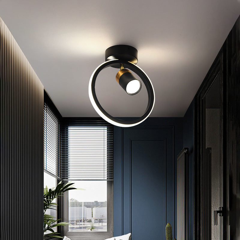 A black ceiling lamp with a glowing white LED ring and a central gold tipped spotlight.