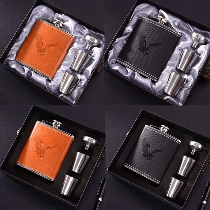 A set of four stainless steel hip flasks wrapped in faux leather (two black, two tan brown) displayed in individual black gift boxes alongside two mini shot mugs and a funnel.