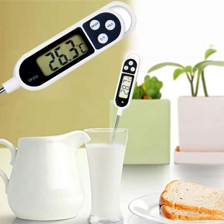 A white digital food thermometer with a long metal probe and a screen displaying a temperature reading.