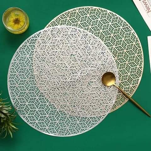 Two circular gold and silver hollow cutout table mats.