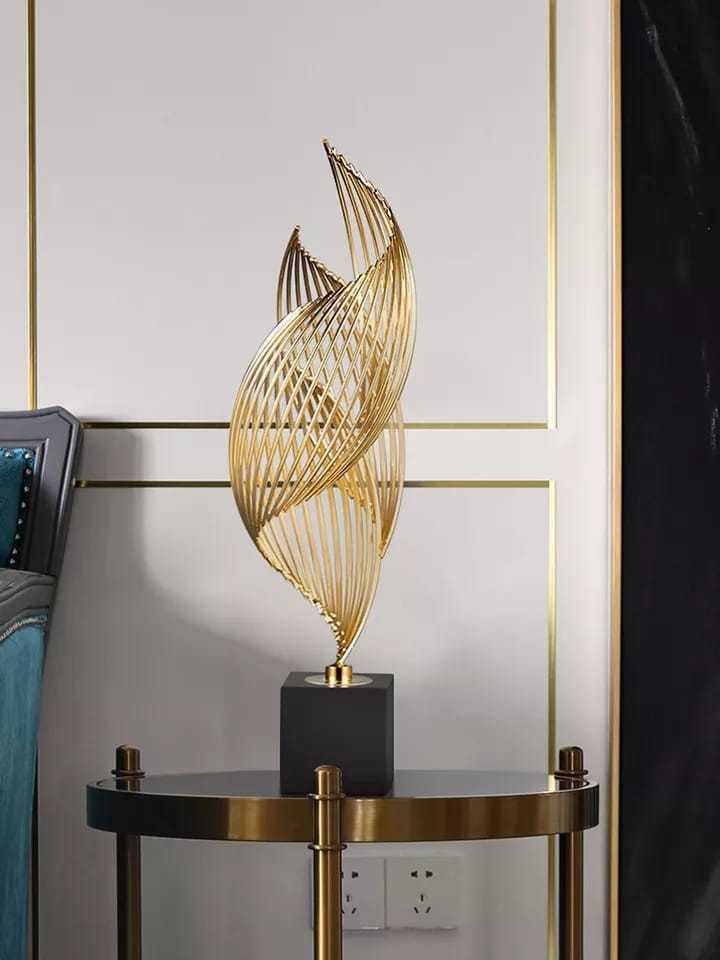 A 46cm tall gold spiral metal abstract sculpture with a black base