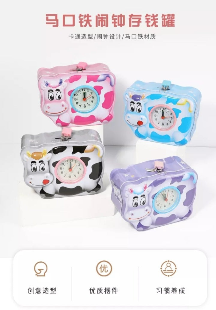 Cow shaped metal piggy banks with built in clocks in various colors.