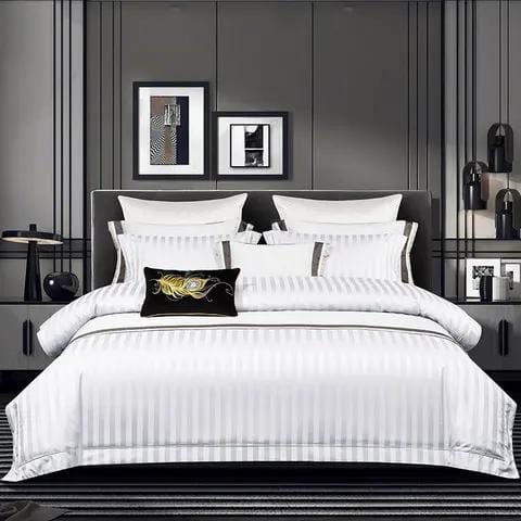 A luxury white duvet cover with stripes, displayed on a bed in a stylishly decorated room.
