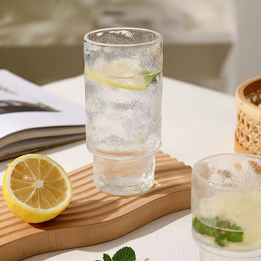 Tall, clear textured glass filled with iced water and lemon slices.