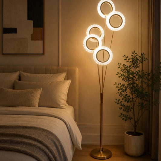 A modern floor lamp with four glowing circular rings on a slim gold stand.