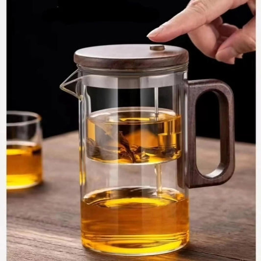 Clear borosilicate glass tea infuser pot with a dark brown wooden style handle, lid, and a metal press mechanis