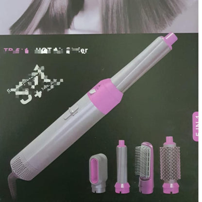 Box art showing a gray and pink 5 in 1 electric hot air hair styler with four detachable heads, including a round brush, paddle brush, and curler attachments.