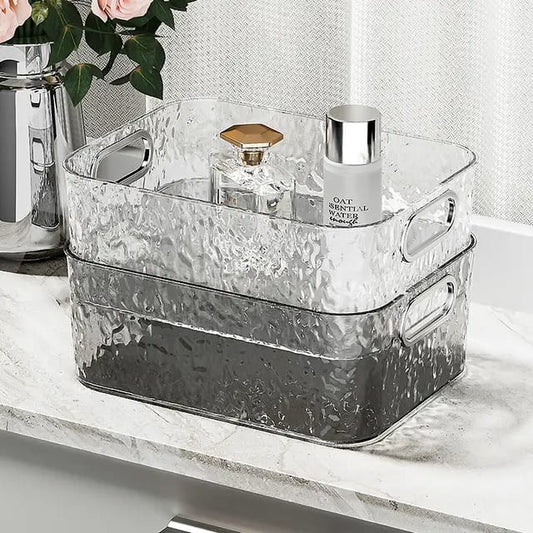 Two clear acrylic textured organizer bins stacked on a marble countertop.