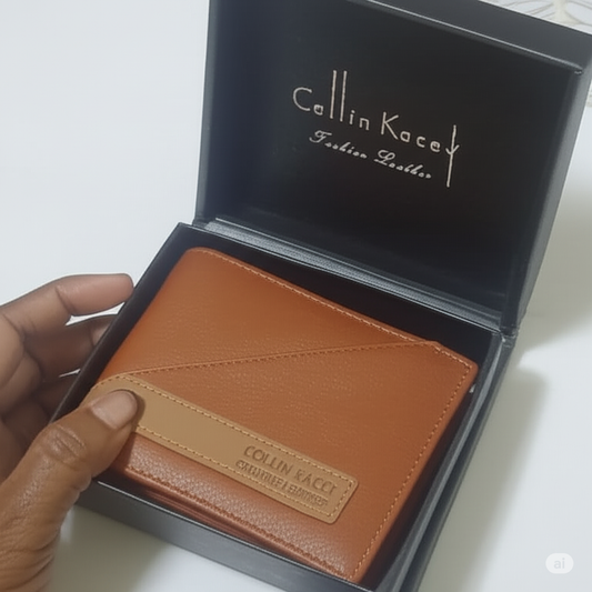 A hand holding a brown leather bi fold men's wallet with a tan accent band, inside a black "Collin Kacey" branded gift box.