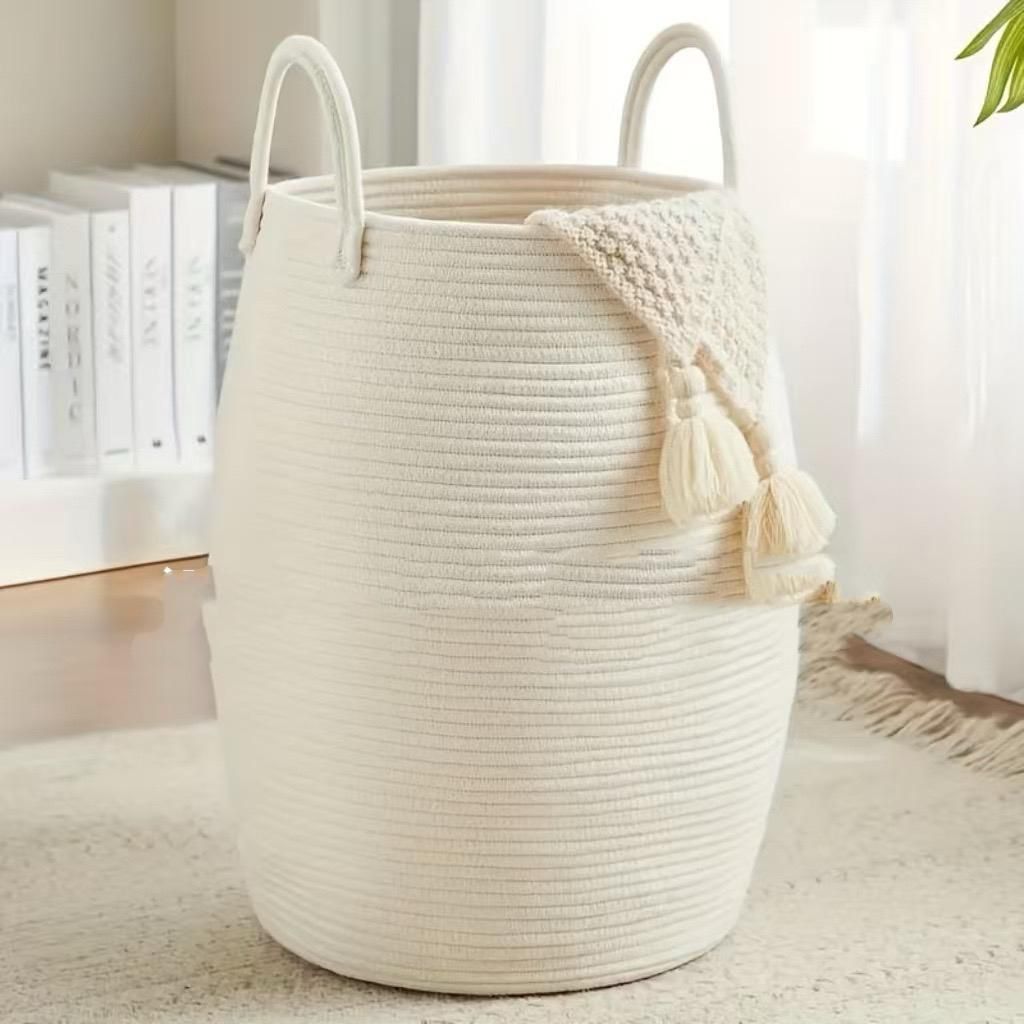 A large woven cotton rope basket with tall handles 