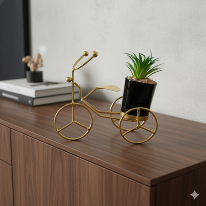 Gold decorative bike sculpture with a plant 