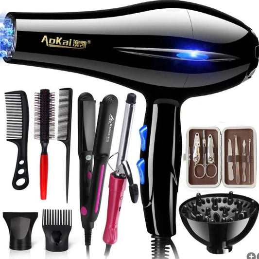 Black 1200 W professional hair dryer with blue accent lights surrounded by various styling accessories including brushes, combs, a hair straightener, curling iron, diffuser, and manicure set.