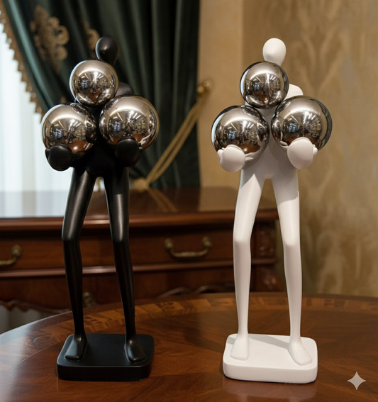 Abstract ceramic figures holding three chrome spheres