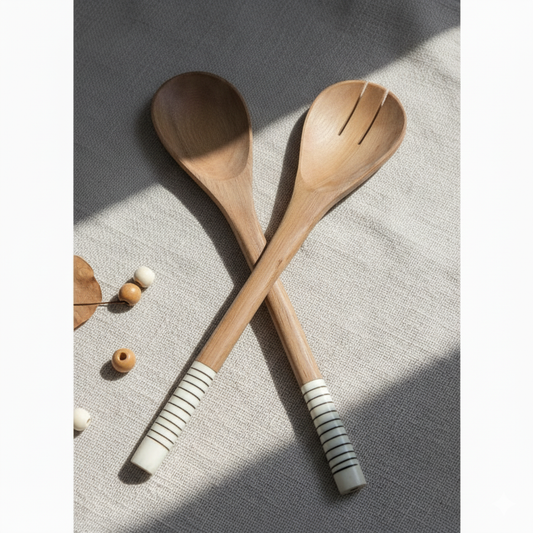 Two wooden salad servers, one solid and one slotted, with handles wrapped in Maasai beads,