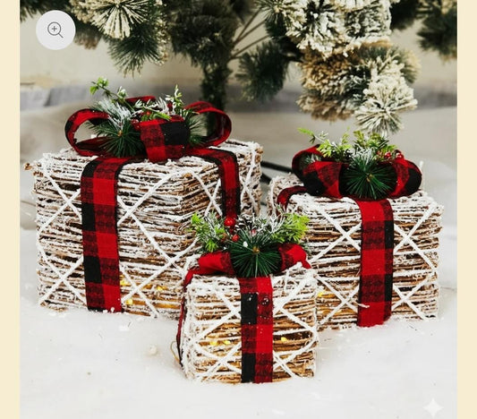 Decorative Christmas presents gift boxes with plaid ribbons on a snowy background